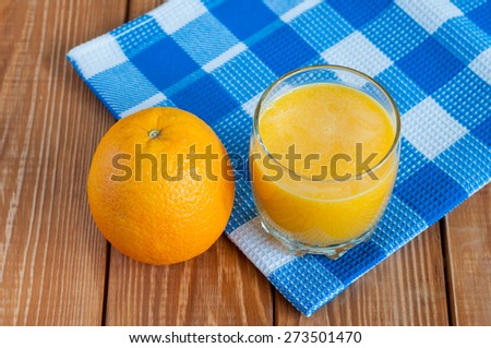 Healthy homemade orange juice in glass and fresh fuit on blue checkered towel and wooden background. Weight loss, healthy food, diet and detoxification