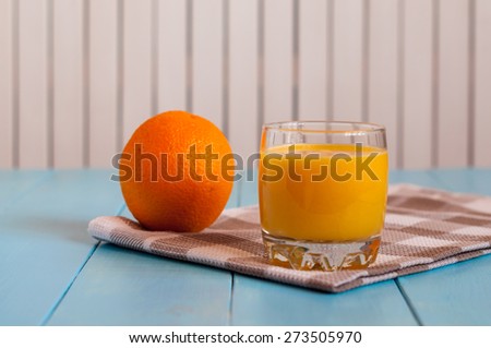 Healthy homemade orange juice in glass and fresh fuit on grey checkered towel and wooden background. Weight loss, healthy food, diet and detoxification