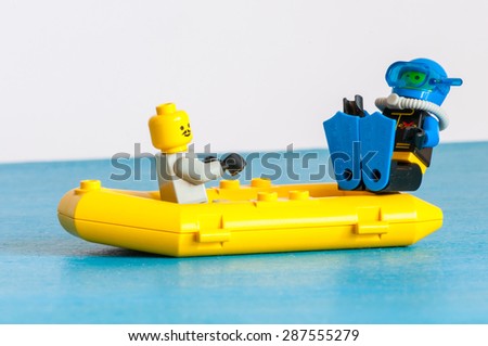 KIEV, UKRAINE - JUNE 14, 2015: Studio shot of Lego minifigure scuba diver in yellow boat. Legos are a popular line of plastic construction toys manufactured by Lego Group, a company based in Denmark.