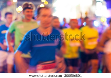 Blurred anonymous crowd of people running on a City Marathon.