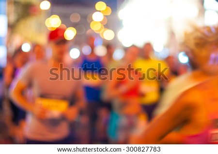 Motion blurred pedestrians run night street. Sport background