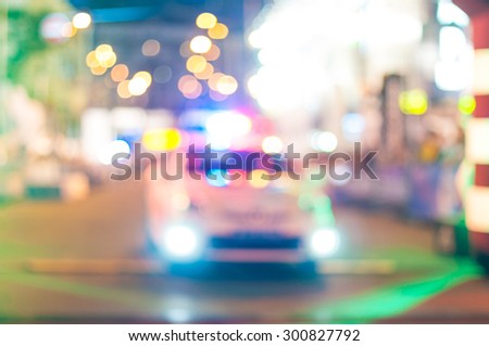 Motion blurred police car with lights turned on at night city
