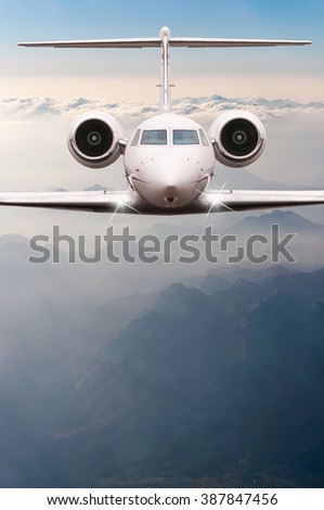 Airplane fly over clouds and Alps mountain on sunset. Front view of a big passenger or cargo aircraft, business jet, airline. Travel concept. Empty space for text