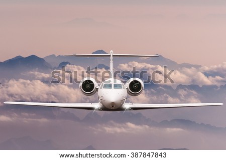 Travel concept. Front view of Jet airliner in flight with sky, cloud and mountain background. Commercial passenger or cargo aircraft, business jet fly over Alps.