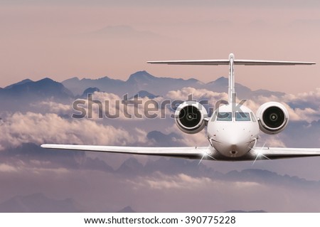 Private Jet plane over clouds and Alps mountain on sunset. Front view of a big passenger or cargo aircraft, business jet, airline. Travel concept. Empty space for text
