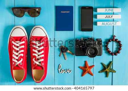 Summer outfit of traveler, student, teenager, girl, young woman or guy. Overhead Of essentials for modern Young person. Different objects on blue wooden background