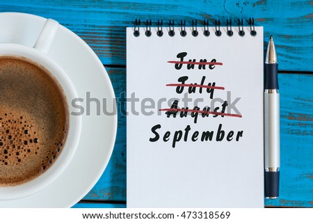 September beginning and summer end concept written at notepad with morning cup of coffee. Striked June, July, August