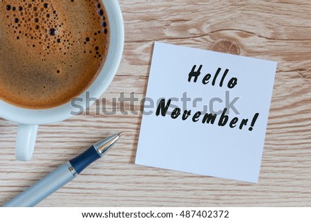Hello November. hand drawn lettering on notepad at the table with morning coffee cup. Top view