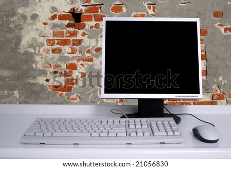 PC with black desktop  and old grunge brick wall background