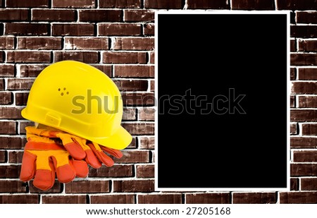 Yellow hard hat and  protective gloves with grunge wall background. Lots of space for your text.