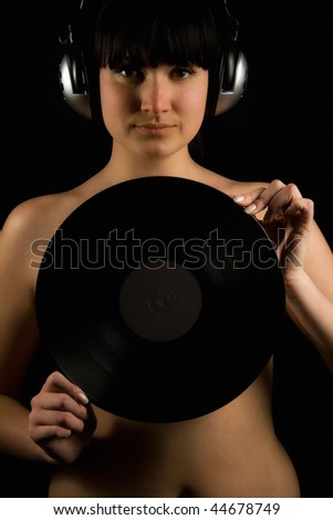 Naked girl with vinyl plate and headphones