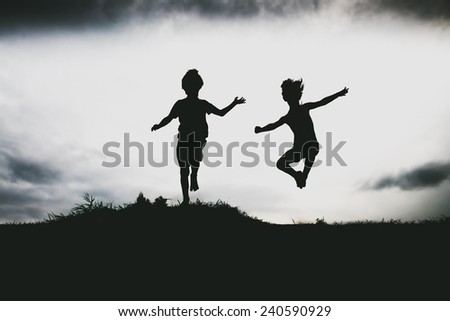 Silhouettes of kids jumping from a cliff