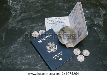 Two US passports on black background. American citizenship. Traveling around the world. Small glass globe on open document. Coins on a side