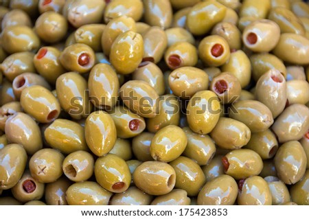 a heap of stuffed green olives in the market