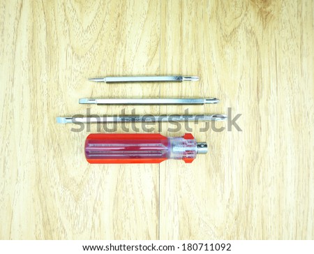 Many size of screwdriver, remove the handle out, handle with red colour, tiled arrangement on the table.