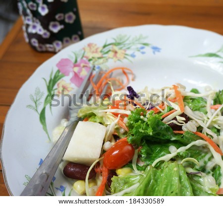 Salad topped with thick cream, mix well, put in a dish ready to eat.