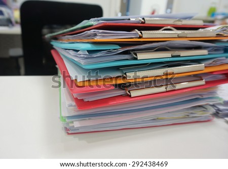 Stack of plastic clipboard and file document placed on desk at office.
