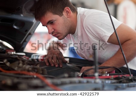 Car repair mechanic fixing auto. Man working on car in garage. At home do it yourself. Examine / inspect engine compartment for trouble; diagnose and fix / correct problem; preventative maintenance.