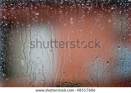Rain drops on window glass. Weather outside, poor conditions drab dreary bleak cold, water streaming down inside of fogged glass.