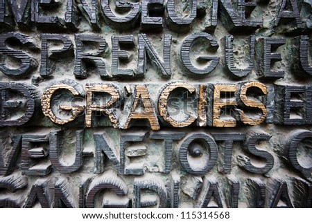 BARCELONA, SPAIN - APRIL 22, 2010: Pattern of raised letters covered with patina, GRACIES gold highlighted in center on April 22, 2010 in the #1 tourist attraction, Sagrada Familia, Barcelona, Spain.