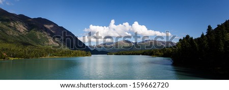 Kenai River in Alaska flows past forests and mountains in the wilderness