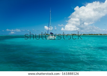 White sailboat moored in bright turquoise blue Caribbean waters