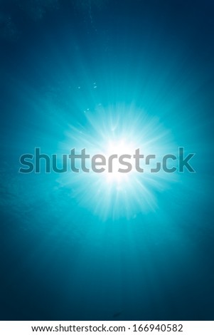 Burst of sunlight shines through ocean waters