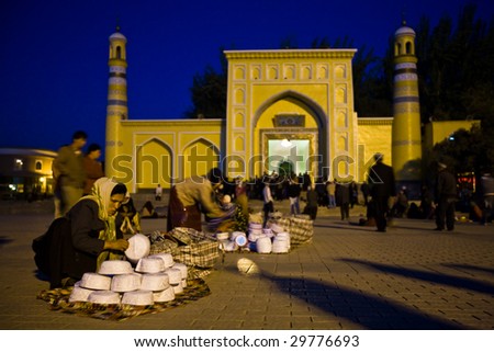 KASHGAR, CHINA - OCT. 2 : Uyghur women sell Muslim skull caps in front of Id Kah Mosque before dawn on the last day of Ramadan October 2, 2008 in Kashgar,  Xinjiang province western China.