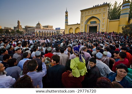 KASHGAR, CHINA - OCT 2 : Crowd watche Uyghur men dance outside Id Kah Mosque after service at the end of Ramadan October 2, 2008 in Kashgar, Xinjiang province western China.