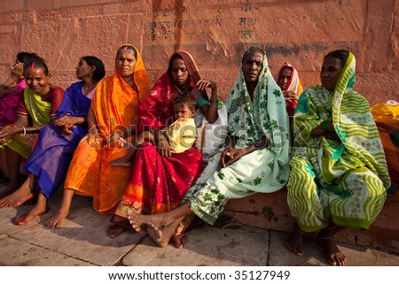 VARANASI, INDIA - JULY 22: Group of Indian women in colorful saris sit and watch the solar eclipse from the banks of the Ganges River July 22, 2009 in Varanasi, India.