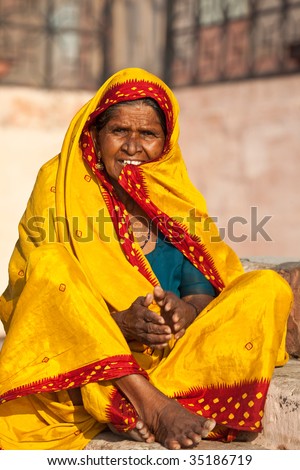 VARANASI, INDIA - JULY 22: An India woman in yellow sari sits on the steps of the ghats viewing the sun emerge from a full solar eclipse July 22, 2009 in Varanasi, India.