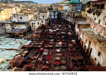 FEZ, MOROCCO - DEC 22: Colorful tanning pools and unidentified workers at a traditional leather tannery,  located in the heart of a neighborhood in a crowded Fez suburban Dec 22, 2009 in Fez, Morocco.