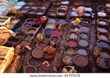 FEZ, MOROCCO - DEC 22: Unidentified laborers dye animal hides in colorful tanning vats at a traditional leather tannery,  December 22, 2009 Fez, Morocco.