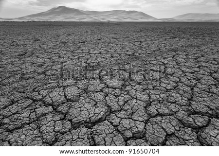 Cracked pattern of dry lake bed in Sahara Desert Morocco in black and white