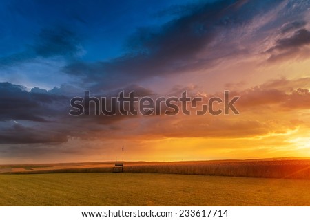 Dramatic sunset over fields with clouds during late summer