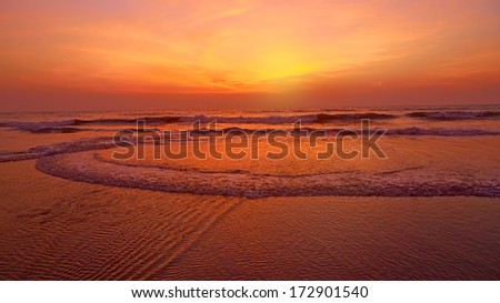 Sea at sunset. Unusual red color and circles on the water. Natural abstract background.