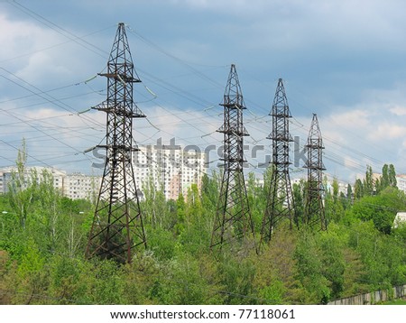 Electric Power Transmission Lines, living houses and cloudy sky