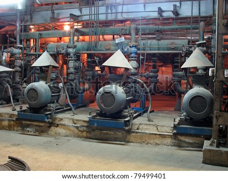Electric motors driving water pumps at power plant, night scene