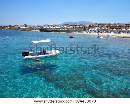 Boat over cerulean clear water on Crete coast, Greece