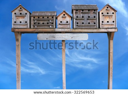 Old wooden starling nesting boxes bird house over blue sky background