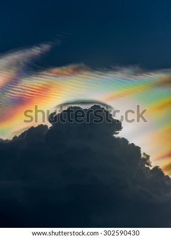 Cloud iridescence behind dark rain cloud : diffraction phenomenon produce very vivid color and make cloud shine like a corona.