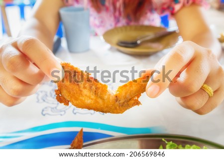 Women eating chicken wings.Thai food.