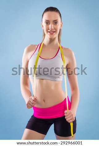 Fitness Woman With Tape Measure On Blue Background