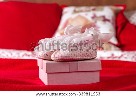 Pink Baby Shoes On Pink Gift Box In Red Bed