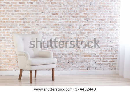 White Armchair On Brick Wall Background Near Window