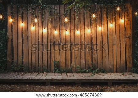 Evening Wooden Stage In The Garden With Lamps For Parties Or Wedding