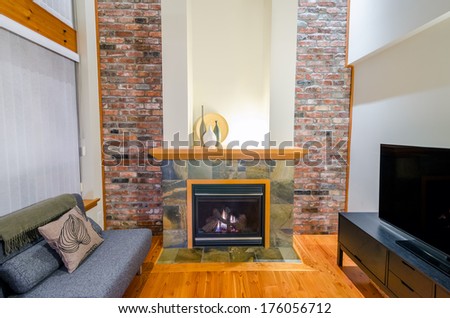 Interior design of a luxury living room with a brick wall and fireplace with a sofa and a pillow