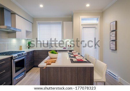 Modern Kitchen Interior With Island And Cabinets In A Luxury House Set For Dinner