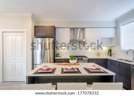 Modern Kitchen Interior With Island And Cabinets In A Luxury House Set For Dinner