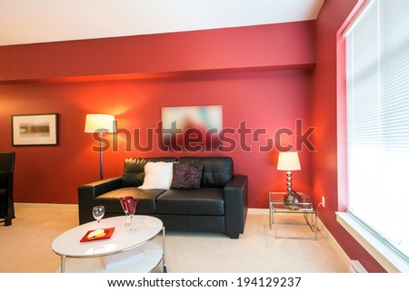 Modern bright, red living room and kitchen with dining room in a luxury house. Interior design.